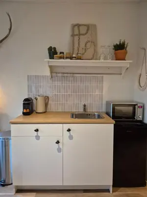 a kitchen with a sink and a microwave at Amsterdam Beach House in Zandvoort