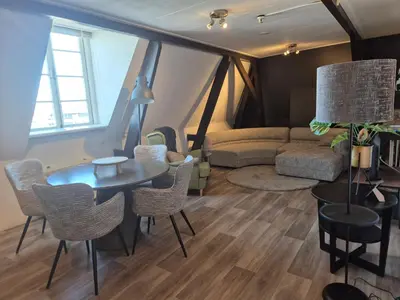 a living room with a table and chairs and a couch at Amsterdam Beach House in Zandvoort