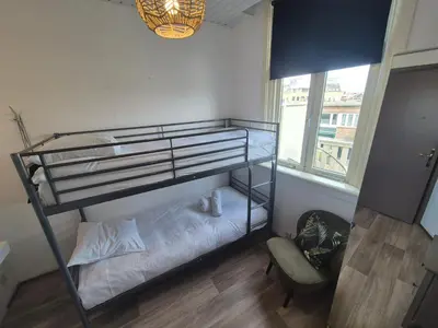 a bedroom with a bunk bed and a chair at Amsterdam Beach House in Zandvoort
