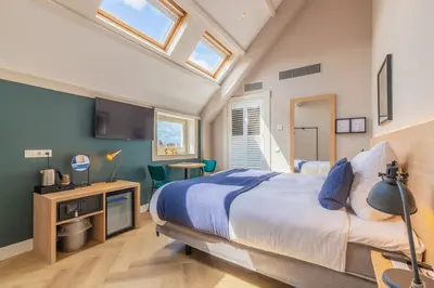 a bedroom with a bed and a tv in it at City Hotel Rembrandt in Leiden