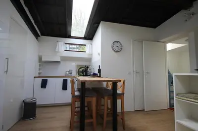 a kitchen with a table and a clock on the wall at studio Vincent van Gogh in Amsterdam