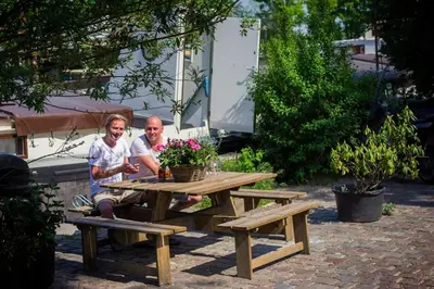 two people sitting at a picnic table with flowers at studio Vincent van Gogh in Amsterdam