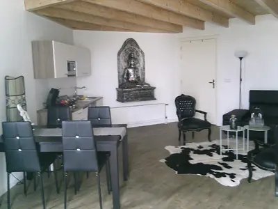 a dining room with a table and chairs and a kitchen at BedStay41 in Oudewater