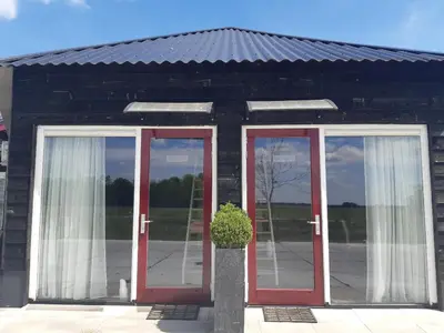 a building with red doors and a potted plant at BedStay41 in Oudewater