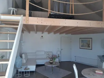 a living room with a loft bed and a table at BedStay41 in Oudewater