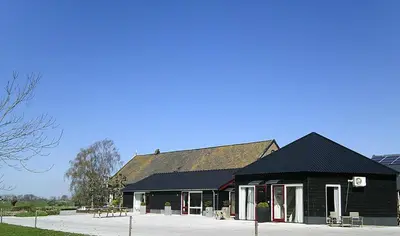 a black building with a black roof and a table at BedStay41 in Oudewater