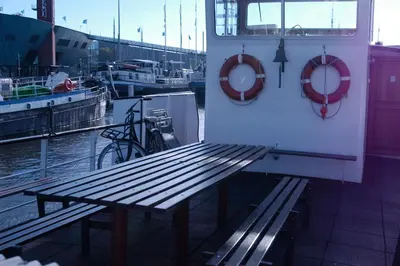 a wooden bench on the side of a boat at Passengership Avanti in Amsterdam