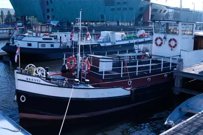 a boat docked at a dock with other boats at Passengership Avanti in Amsterdam