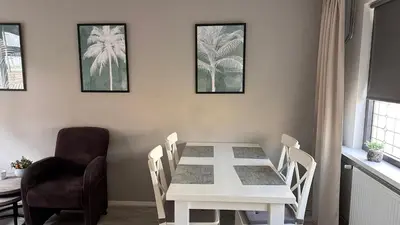 a dining room with a white table and a chair at Beach-house27 in Egmond aan Zee