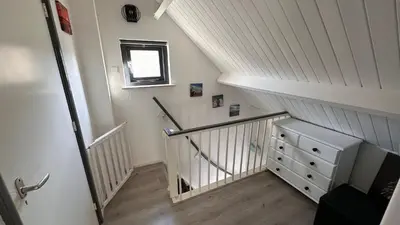 a stairway with a white stair railing and a drawer at Beach-house27 in Egmond aan Zee