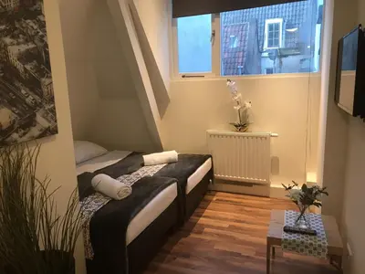 a small room with a bed and a window at Central sweet BNB in Amsterdam