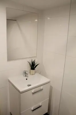 a white bathroom with a sink and a mirror at Central sweet BNB in Amsterdam