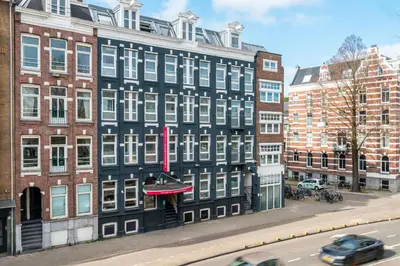 a black building with white windows on a city street at Leonardo Hotel Amsterdam Leidse Square in Amsterdam