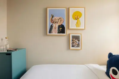 a bedroom with four pictures on a wall at Leonardo Hotel Amsterdam Leidse Square in Amsterdam