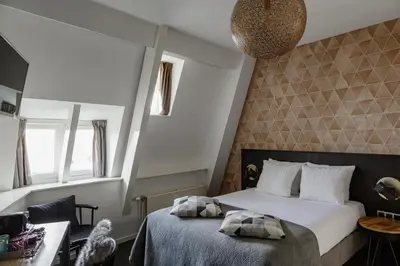a bedroom with a bed and two windows at Boutique Hotel View in Amsterdam