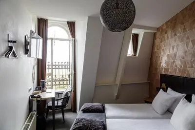 a hotel room with a bed and a desk and a window at Boutique Hotel View in Amsterdam