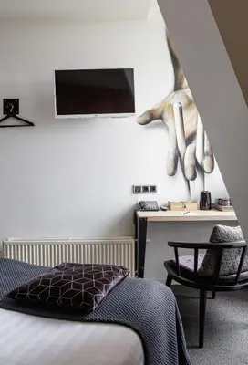 a bedroom with a bed and a tv on the wall at Boutique Hotel View in Amsterdam
