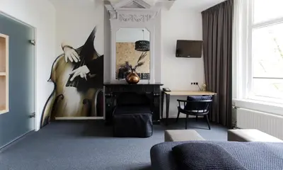 a room with a table and a mirror and a desk at Boutique Hotel View in Amsterdam