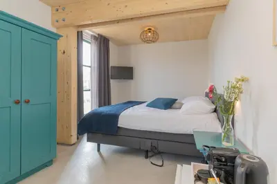 a bedroom with a bed and a vase of flowers at De Groene Bollenschuur in Hillegom