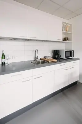 a white kitchen with a sink and a microwave at Kranenbergh Boutique Apartments in Bergen