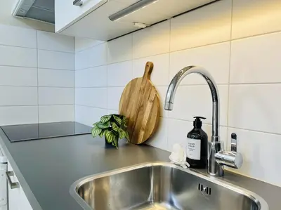 a kitchen counter with a sink and a wooden cutting board at Kranenbergh Boutique Apartments in Bergen