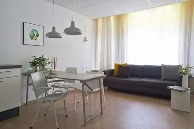 a living room with a table and a couch at Kranenbergh Boutique Apartments in Bergen