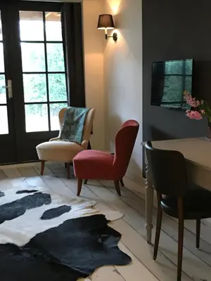 a living room with two chairs and a table at Nabij de Molen in Wijdenes