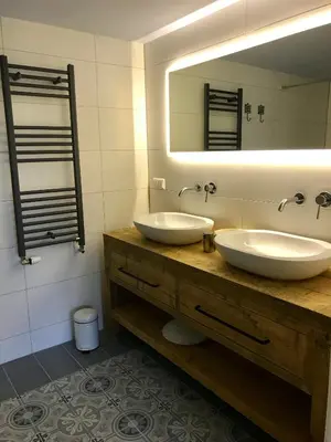 a bathroom with two sinks and a large mirror at Nabij de Molen in Wijdenes