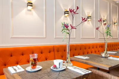 two tables in a restaurant with vases and drinks at Amsterdam Canal Hotel in Amsterdam