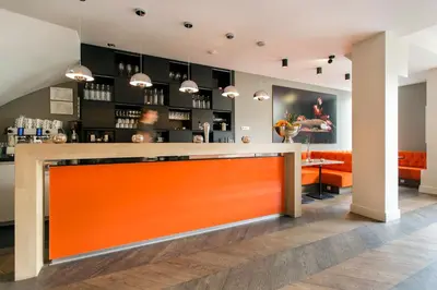 a bar in a restaurant with an orange counter at Amsterdam Canal Hotel in Amsterdam