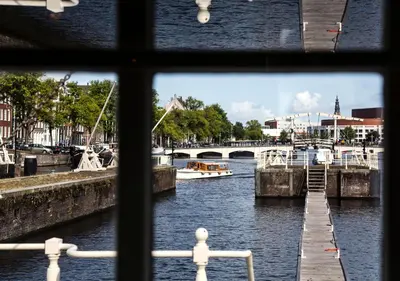 a view from a window of a river with boats at SWEETS - Amstelschutsluis in Amsterdam