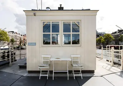 a small building with a table and two chairs at SWEETS - Amstelschutsluis in Amsterdam