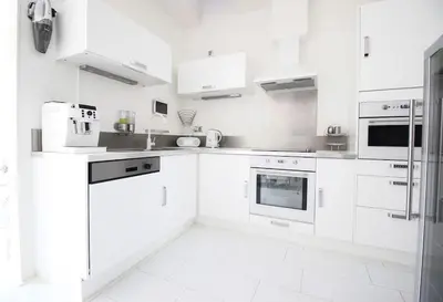 a white kitchen with white cabinets and appliances at White Luxury Penthouse in City Centre in Amsterdam