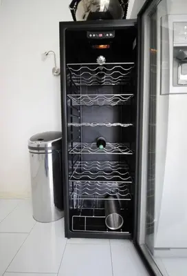 a black wine rack in a kitchen with a trash can at White Luxury Penthouse in City Centre in Amsterdam