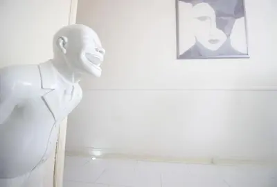 a statue of a mannequin standing next to a wall at White Luxury Penthouse in City Centre in Amsterdam