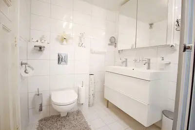 a white bathroom with a toilet and a sink at White Luxury Penthouse in City Centre in Amsterdam