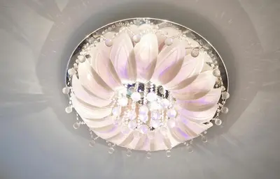 a fancy ceiling light with a pink flower on it at White Luxury Penthouse in City Centre in Amsterdam