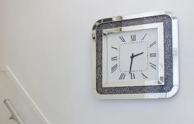 a clock on a wall with a silver frame at White Luxury Penthouse in City Centre in Amsterdam