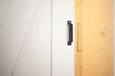 a white door with a black handle next to a closet at Achter de duinen in Zandvoort