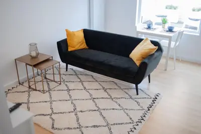 a black couch in a living room with a table at Achter de duinen in Zandvoort