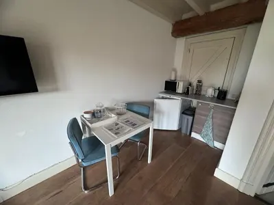a small kitchen with a white table and chairs at Ora et Labora in Beets