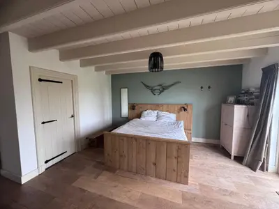 a bedroom with a bed with a whale on the wall at Ora et Labora in Beets