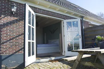a door leading into a room with a bed inside at Ora et Labora in Beets