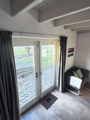 a room with a sliding glass door and a couch at Ora et Labora in Beets