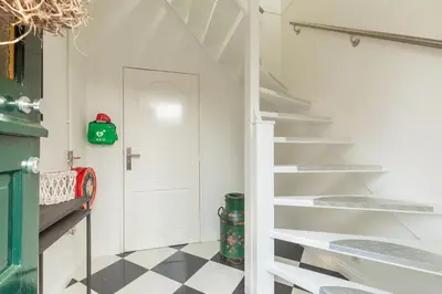 a white staircase in a room with a checkered floor at B&B Blossom in Lisse