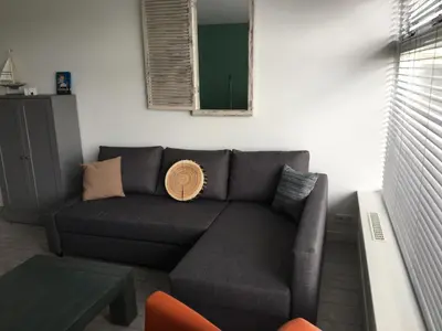 a living room with a couch and a table at Amsterdam Beach Home 46 in Zandvoort