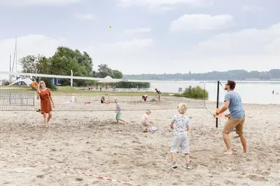 a group of people playing soccer on the beach at RCN Zeewolde in Zeewolde