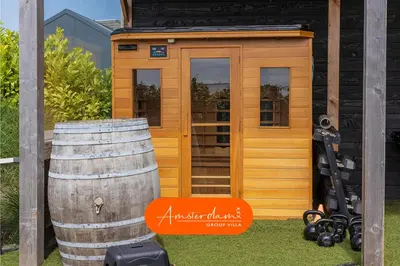 a small cabin with a barrel in front of it at Amsterdam Group Villa 20 plus beds 4 - 5 bedrooms in Zwanenburg