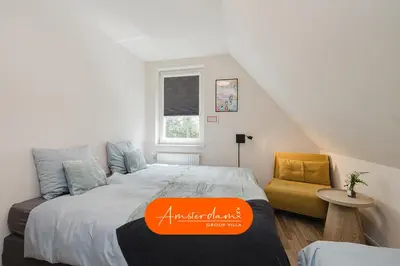 a bedroom with a bed with an orange sign on it at Amsterdam Group Villa 20 plus beds 4 - 5 bedrooms in Zwanenburg
