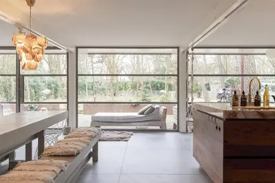 a living room with a table and some windows at Villa in the forest near the beach in Bergen